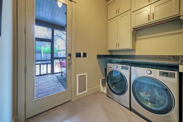 laundry area with baseboards, washer and clothes dryer, cabinet space, and tile patterned floors