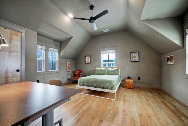 bedroom featuring ceiling fan, wood finished floors, visible vents, baseboards, and vaulted ceiling