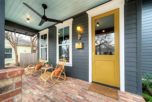 view of exterior entry featuring ceiling fan and a porch