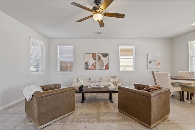 living area with a ceiling fan, light tile patterned flooring, visible vents, and a healthy amount of sunlight