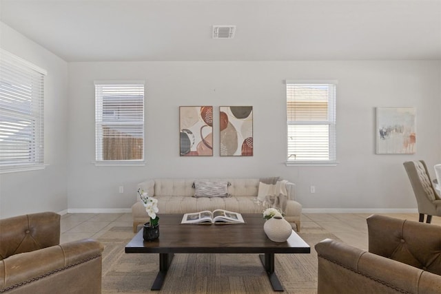 tiled living room featuring baseboards and visible vents