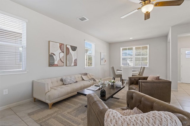 living room with a ceiling fan, visible vents, baseboards, and light tile patterned flooring