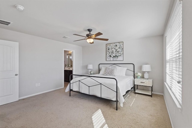 carpeted bedroom with a ceiling fan, visible vents, connected bathroom, and baseboards