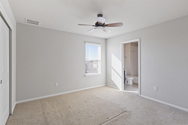 unfurnished bedroom with baseboards, visible vents, connected bathroom, light colored carpet, and a closet