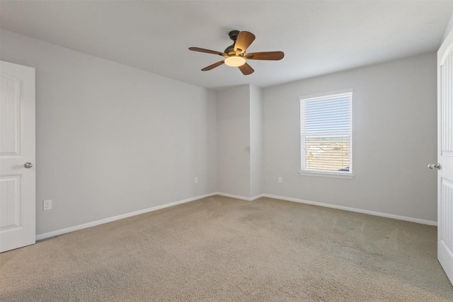 empty room featuring carpet floors, ceiling fan, and baseboards