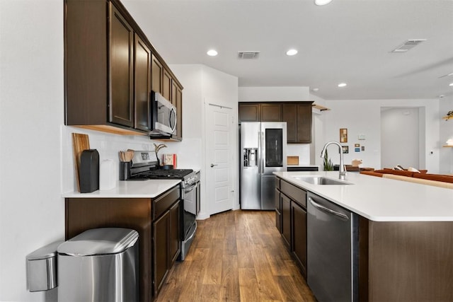 kitchen featuring appliances with stainless steel finishes, visible vents, a sink, and dark brown cabinetry