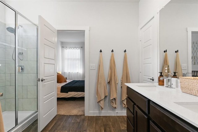 bathroom featuring double vanity, a stall shower, wood finished floors, and ensuite bathroom