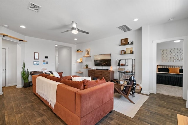 living area with a barn door, dark wood-style flooring, and visible vents