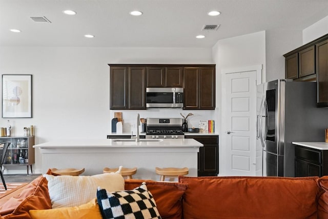 kitchen with visible vents, stainless steel appliances, a sink, and light countertops