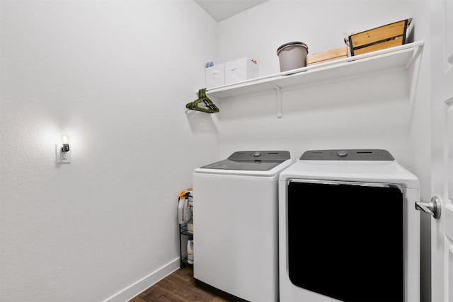 clothes washing area featuring laundry area, baseboards, washer and clothes dryer, and dark wood finished floors