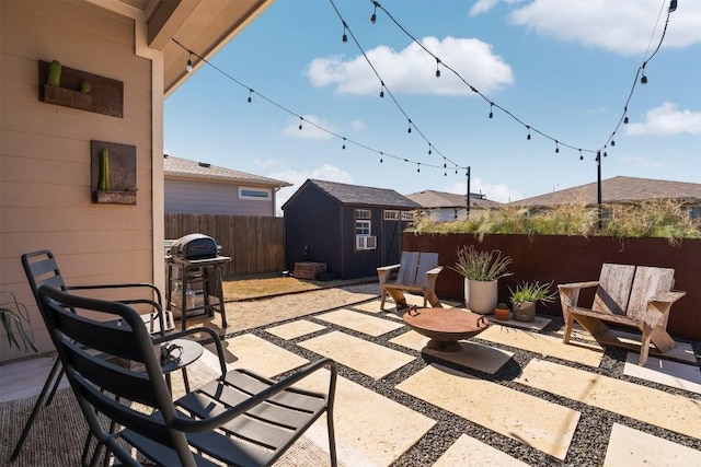 view of patio / terrace with a shed, a grill, a fenced backyard, and an outdoor structure