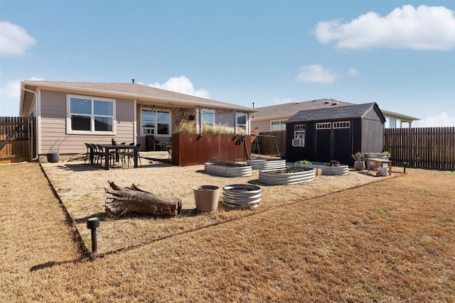 rear view of property with a vegetable garden, a lawn, a storage shed, a fenced backyard, and an outdoor structure