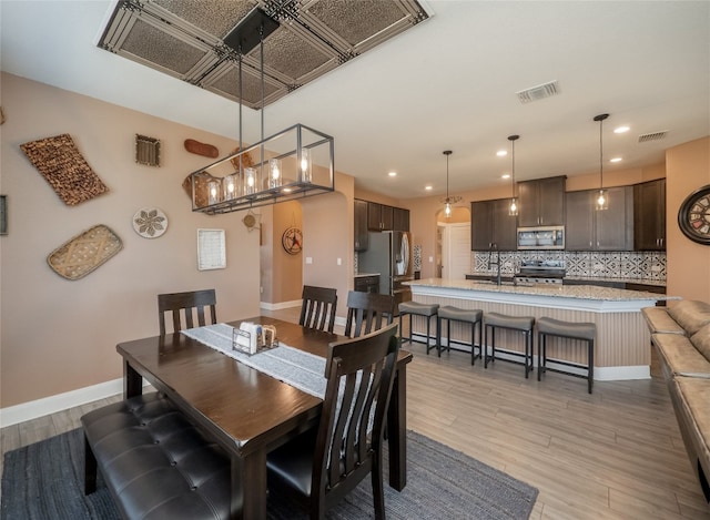 dining area with light wood-style flooring, recessed lighting, visible vents, and baseboards