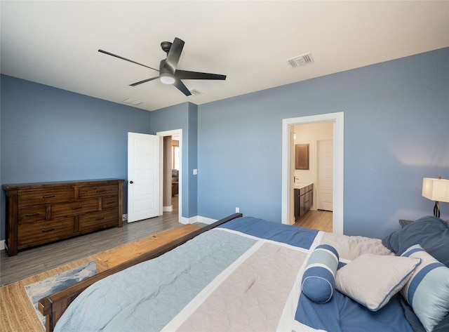 bedroom with light wood finished floors, visible vents, connected bathroom, ceiling fan, and baseboards