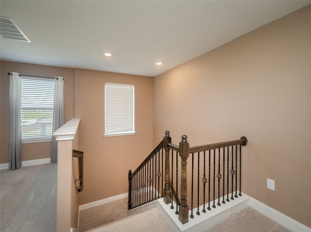 stairs with carpet, visible vents, and baseboards