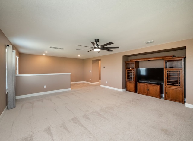 unfurnished living room featuring light colored carpet, visible vents, and baseboards