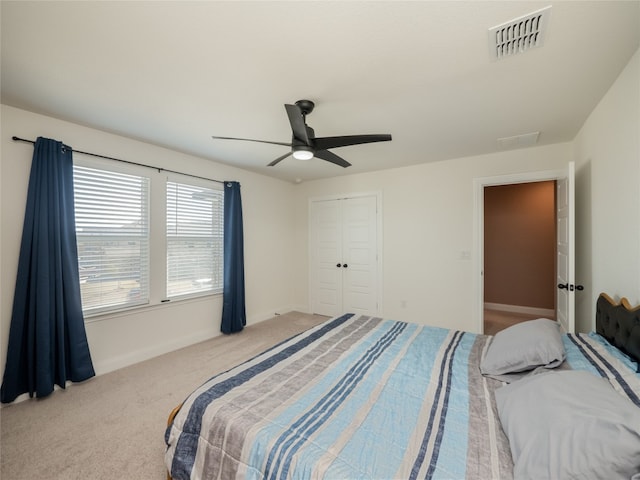 bedroom with carpet flooring, visible vents, baseboards, a ceiling fan, and a closet