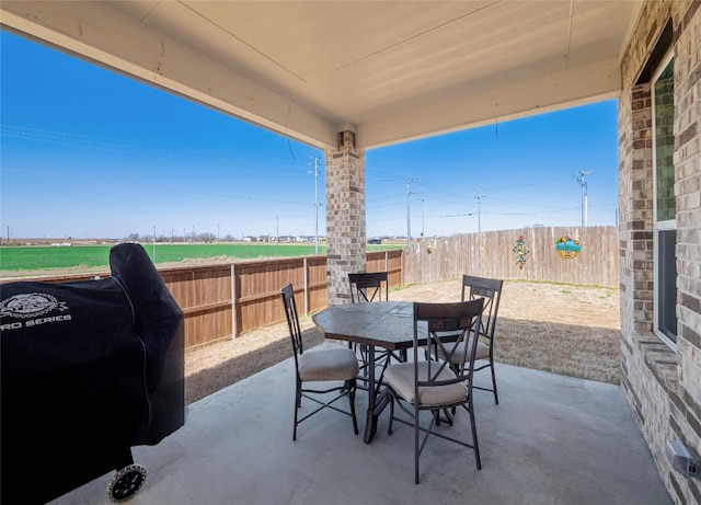 view of patio featuring outdoor dining area, a fenced backyard, and area for grilling