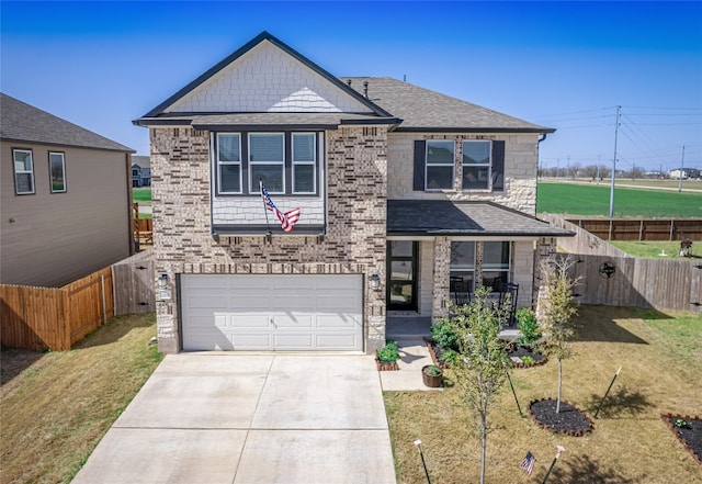 view of front of house with brick siding, a front yard, fence, a garage, and driveway