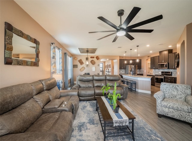 living room with ceiling fan, wood finished floors, and recessed lighting