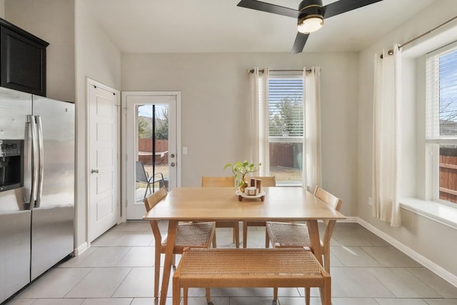 dining room with a healthy amount of sunlight, baseboards, and light tile patterned floors