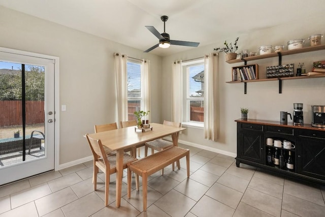 dining space with light tile patterned floors, ceiling fan, and baseboards