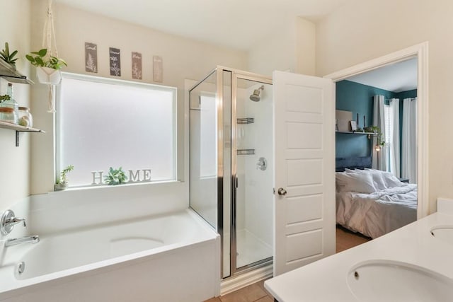 ensuite bathroom featuring a garden tub, double vanity, a stall shower, a sink, and ensuite bath