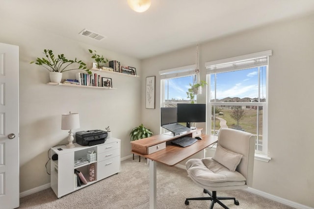 office area featuring baseboards, visible vents, and light colored carpet