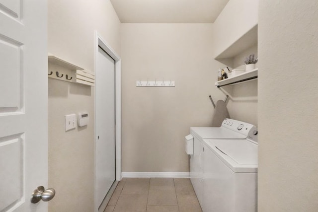 laundry area with laundry area, light tile patterned floors, baseboards, and washer and dryer