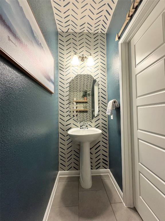 bathroom with tile patterned flooring, baseboards, and a sink