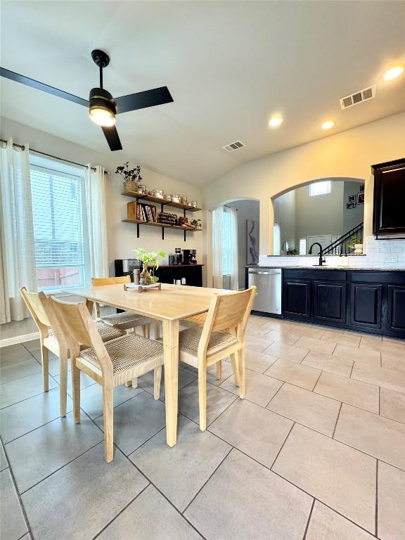 dining area with light tile patterned floors, visible vents, arched walkways, and recessed lighting