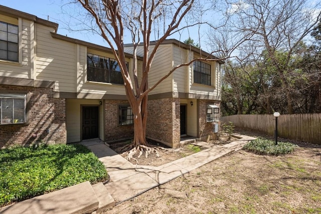 view of front facade with fence and brick siding