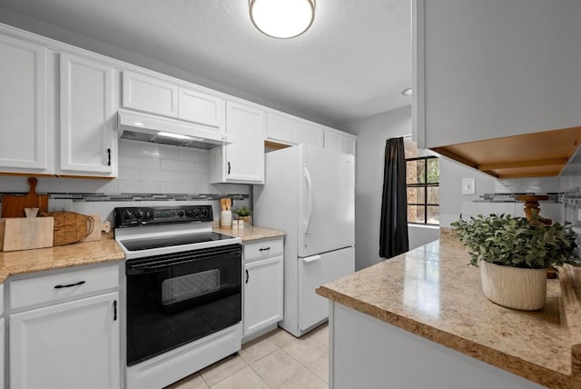 kitchen with tasteful backsplash, electric range oven, freestanding refrigerator, white cabinets, and under cabinet range hood