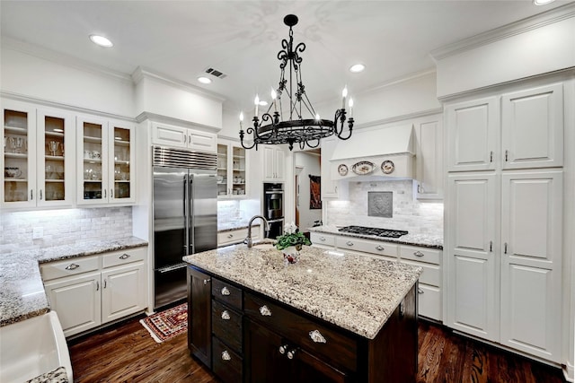 kitchen with stainless steel appliances, white cabinetry, ornamental molding, and custom exhaust hood