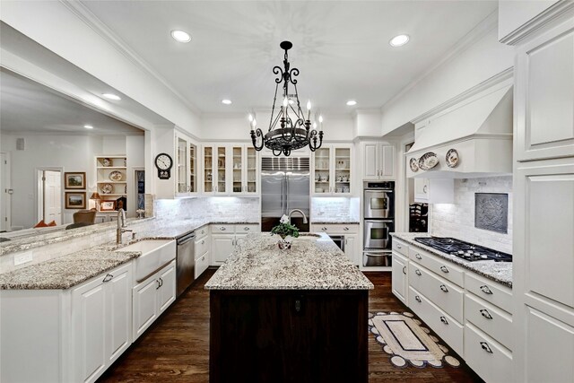 kitchen with stainless steel appliances, crown molding, white cabinets, and backsplash