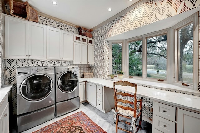 laundry room featuring plenty of natural light, washing machine and clothes dryer, cabinet space, and wallpapered walls