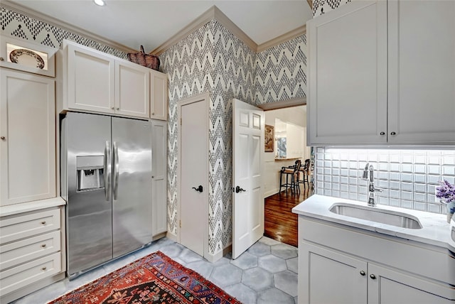 2405 Westlake Pass, Austin, TX 78746 - kitchen featuring stainless steel fridge, wallpapered walls, light tile patterned floors, light stone countertops, and white cabinetry