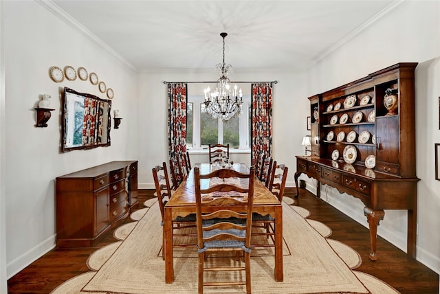 dining room with baseboards, ornamental molding, wood finished floors, and a notable chandelier