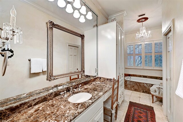 full bath featuring vanity, a chandelier, a garden tub, visible vents, and ornamental molding