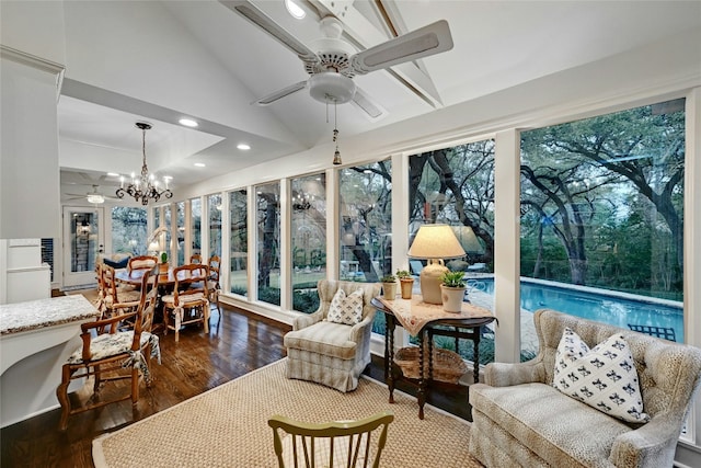 sunroom with vaulted ceiling and ceiling fan with notable chandelier