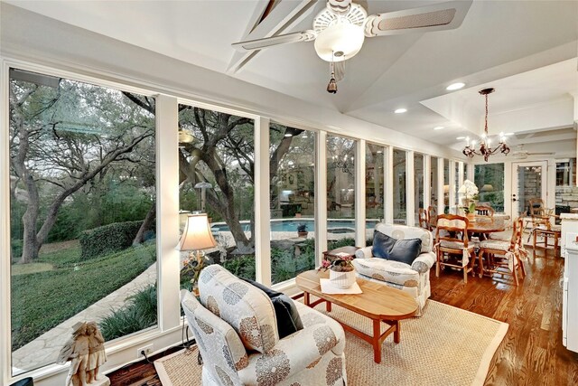 sunroom / solarium featuring recessed lighting, lofted ceiling, a chandelier, and wood finished floors