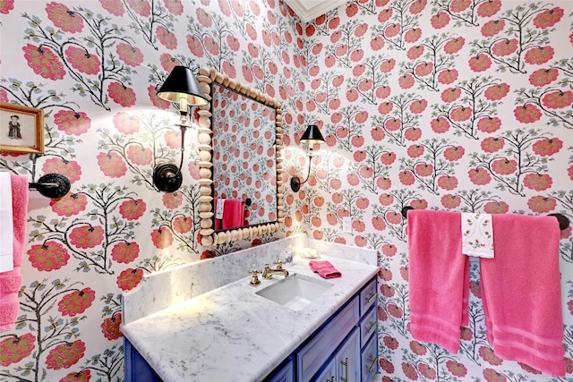 bathroom with wallpapered walls, ornamental molding, and vanity