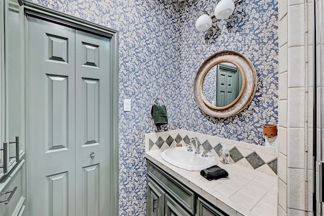 bathroom with wallpapered walls and vanity