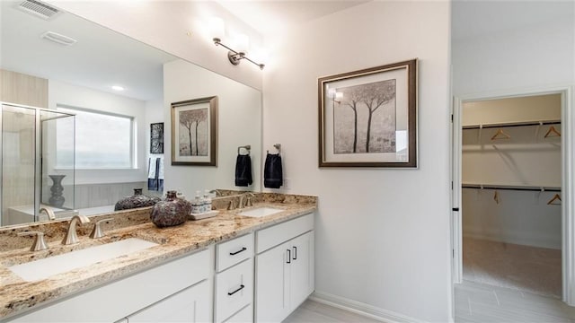 112 Amber Oak Ln, Georgetown, TX 78628 - full bath with double vanity, a stall shower, a spacious closet, and baseboards