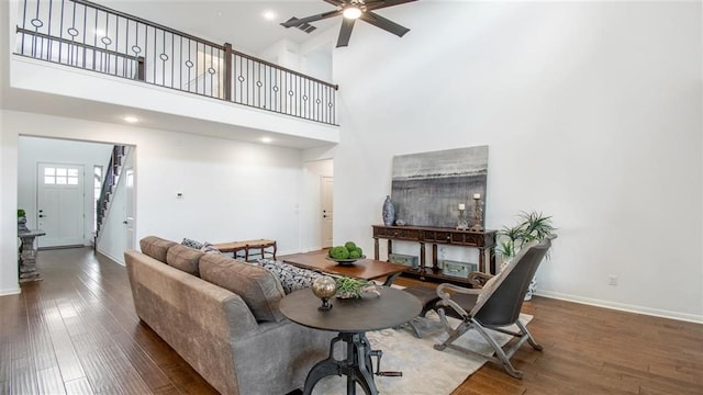 112 Amber Oak Ln, Georgetown, TX 78628 - living room featuring stairway, ceiling fan, wood finished floors, a high ceiling, and baseboards