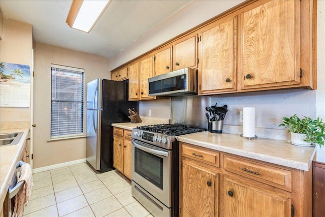 kitchen featuring light tile patterned floors, stainless steel appliances, and light countertops