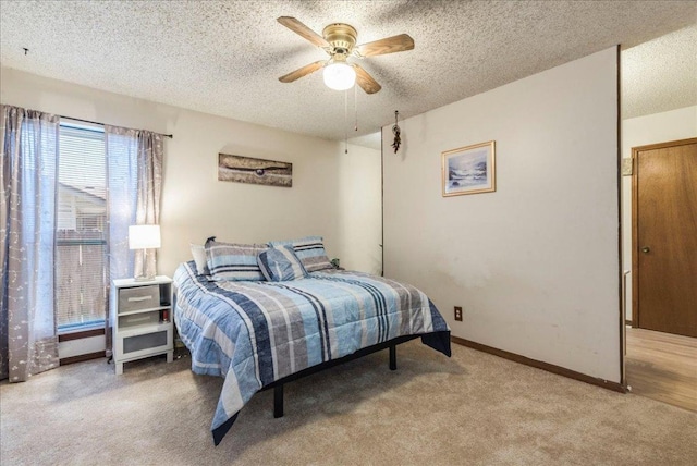 carpeted bedroom with a ceiling fan, a textured ceiling, and baseboards