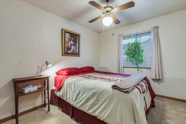 bedroom featuring ceiling fan, baseboards, a textured ceiling, and light colored carpet