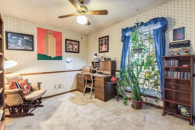 home office with a textured ceiling, a ceiling fan, baseboards, carpet, and wallpapered walls