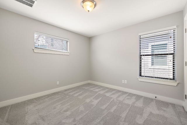 carpeted empty room with visible vents and baseboards